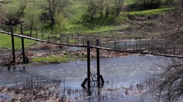 Puente de metal viejo al otro lado del río en el campo en el día soleado — Vídeos de Stock