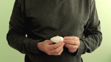 Adam elektrikçi mühendis kamera enerji tasarrufu Led lamba vermek. Eller closeup açık yeşil arka planda izole.