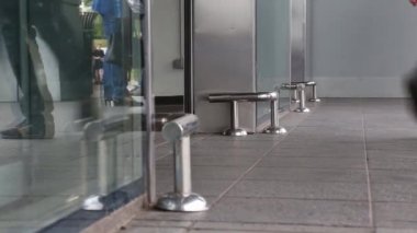 Alışveriş merkezibirçok kişi ziyaretçi alışveriş için cam kapıdan yürümek. Bacaklar yakın çekim, alt görünüm.