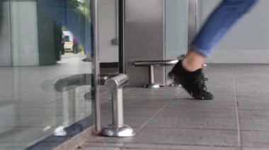 Berlin, Almanya - Mayıs, 2019: Alışveriş merkezini ziyaret eden birçok kişi alışveriş için cam kapıdan giriyor. Bacaklar yakın çekim, alt görünüm.