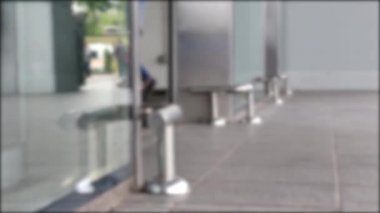 Alışveriş merkezibirçok kişi ziyaretçi alışveriş için cam kapıdan yürümek. Bacaklar yakın çekim, alt görünüm. Bulanık çerçeve.