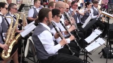 Kryvyi Rih, Ukrayna - Mayıs, 2019: Belediye orkestrasında oturan insanlar açık hava şenlikli konserde nefes çalıyor.