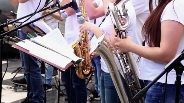 Female musicians play saxophones in municipal orchestra performing at festive concert open air. — Stock Video