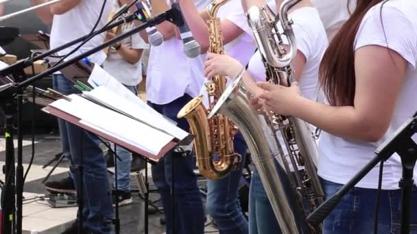 Mujeres músicos tocan saxofones en orquesta municipal actuando en concierto festivo al aire libre . — Vídeos de Stock