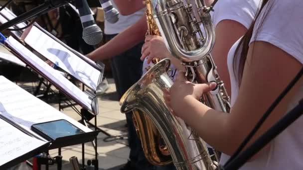 Músicas femeninas tocan saxofones en orquesta municipal actuando en concierto festivo al aire libre . — Vídeo de stock