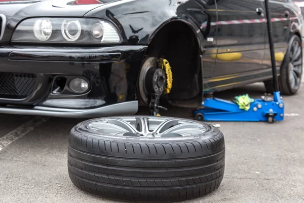 Ön planda sökülmüş araba tekerleği. Araba tamiri.