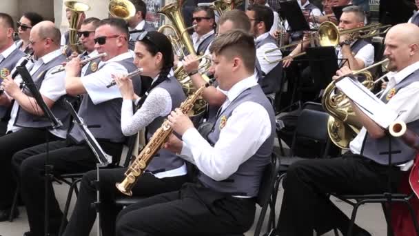 KRYVYI RIH, UCRANIA - MAYO de 2019: Músicos sentados tocan instrumentos de viento en orquesta municipal actuando en concierto festivo al aire libre . — Vídeos de Stock