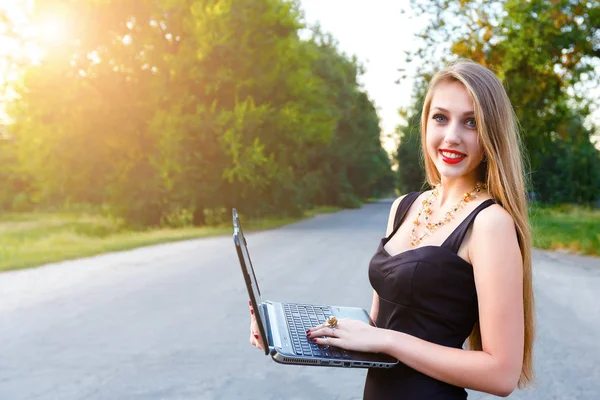 Junge schöne lächelnde blonde Frau hält einen Laptop, — Stockfoto