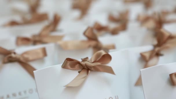 Много Маленьких Белых Бумажных Подарочных Коробок Ленточками Столе Украшение Свадебного — стоковое видео