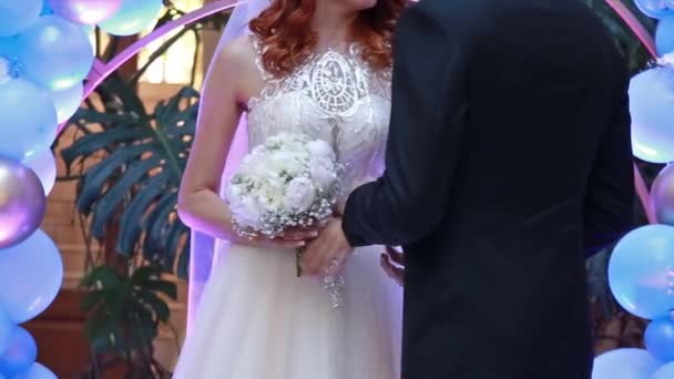 新郎新婦が結婚式に手をつないでいる バラの花束を持つ白いドレスの女性 — ストック動画