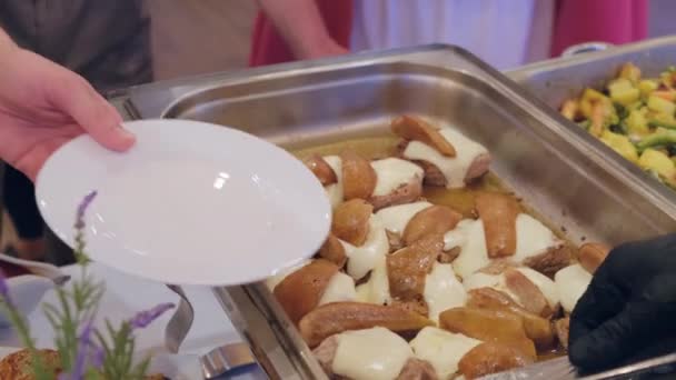 Siyah Eldivenli Garson Şenlikli Bir Resepsiyonda Misafirlerin Tabaklarına Yemek Koyar — Stok video