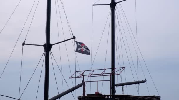 風の強い日に青空の背景に船のマストにぶら下がっている海賊フラグジョリーロジャー — ストック動画