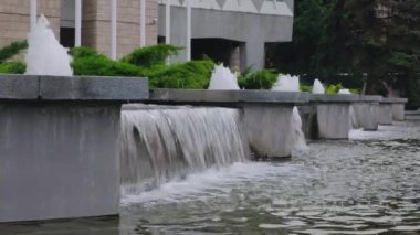 Bir yaz gününde beton şehir çeşmeyakın çekim su dökme.
