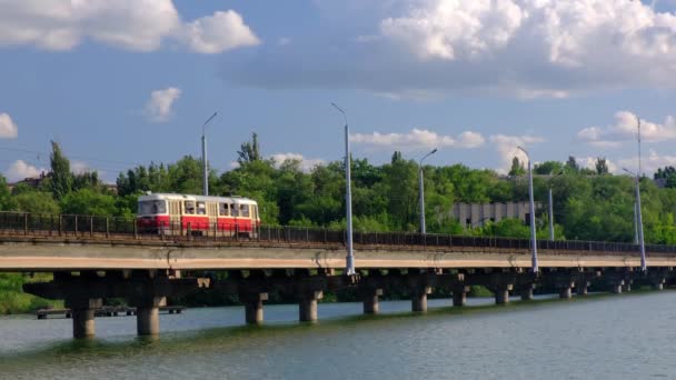 Трамвай Движется Мосту Через Реку Городе Фоне Зеленых Деревьев Голубого — стоковое видео