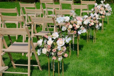 Bir satırda Beyaz ahşap boş sandalyeler ve yeşil çiçekler buketleri