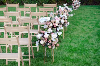 Bir satırda Beyaz ahşap boş sandalyeler ve yeşil çiçekler buketleri