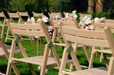 Bir satırda Beyaz ahşap boş sandalyeler ve yeşil çiçekler buketleri