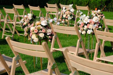 Bir satırda Beyaz ahşap boş sandalyeler ve yeşil çiçekler buketleri