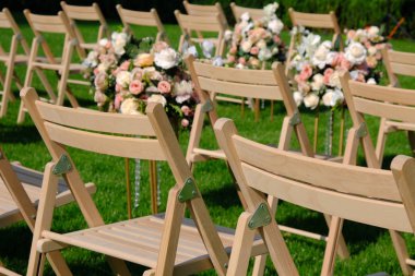 Bir satırda Beyaz ahşap boş sandalyeler ve yeşil çiçekler buketleri