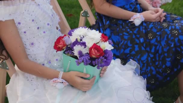 Gäste kleine Mädchen mit Blumensträußen sitzen auf einer Hochzeitszeremonie — Stockvideo