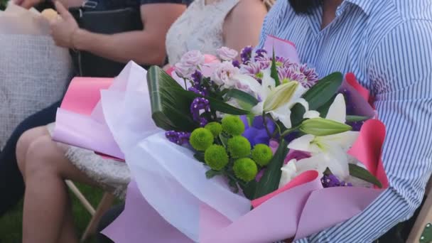 Gäster med en blomma buketter sitter på en bröllopsceremoni — Stockvideo