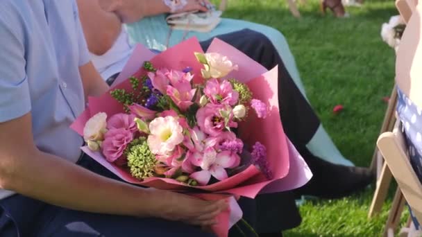 Gasten met een bloem boeketten zittend op een huwelijksceremonie — Stockvideo