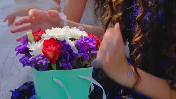 Гості Лістла дівчата з квітковими букетами сидять на весільній церемонії на свіжому повітрі — стокове відео