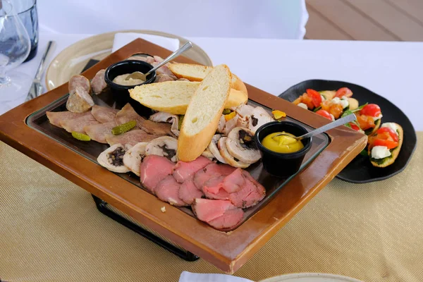 Chutné uzené nakrájené maso na dřevěném tácu na banketu v — Stock fotografie