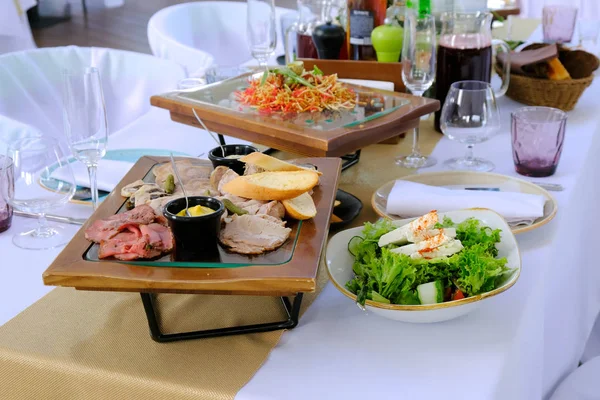 Savoureux bacon coupé fumé sur un plateau en bois sur une table de banquet dans — Photo