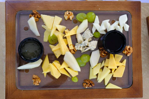 Varios tipos de queso cortado en una bandeja de madera en un banquete ta — Foto de Stock