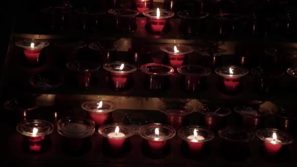 El grupo de velas de la iglesia es Burn. Velas encendidas en un templo en la oscuridad — Vídeo de stock