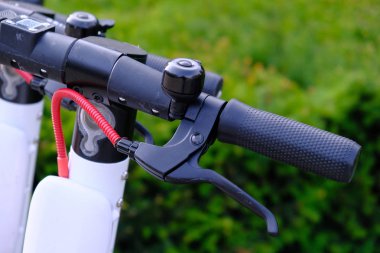 Eectric scooter yeşil yaprakları backgr bir şehir kaldırımda park