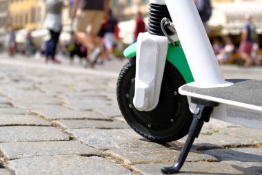 Elektrikli scooter eski şehir merkezinde kaldırıma park etmiş. Tekerlek cl