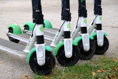 Dört elektrikli scooter Lime-S bir şehir kaldırımda üst üste park