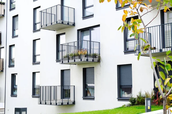 Balkonu ve beyaz binaları olan modern bir apartman dairesi.