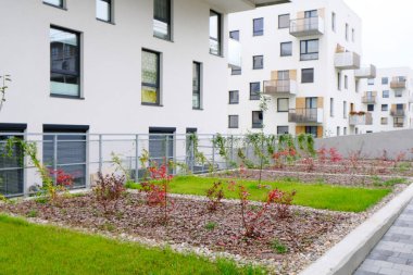 Modern apartmanların avlusunda rahat bir bahçe.