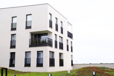 Balkonu ve beyaz duvarları olan modern bir apartman. Gerçek e