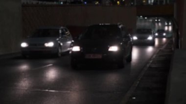 Birçok araba gece şehir caddesi boyunca farları açık olarak sürer. Trafik, şehir gece hayatı, bulanık çerçeve..