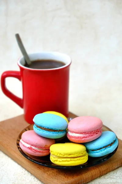 Bunte Französische Süßgebäckmakronen Auf Glastisch Und Roter Kaffeebecher Auf Holztablett — Stockfoto