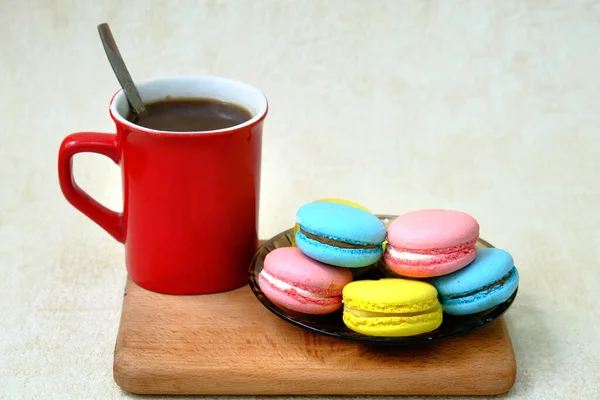 五彩缤纷的法国甜糕点放在玻璃桌上 红咖啡杯放在木制托盘上 — 图库照片