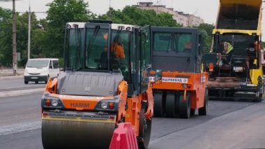 KRYVYI RIH, UKRAINE - Haziran 2020. Şehir caddesinde çalışan yol silindirleri. Yeni karayolu inşaatında ağır endüstriyel makineler.