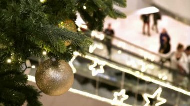 Sopping Mall 'da Noel süsleri. Şenlik alışveriş merkezinde yürüyen merdivendeki insanlar yeni yıl alışverişi yaparlar.,.