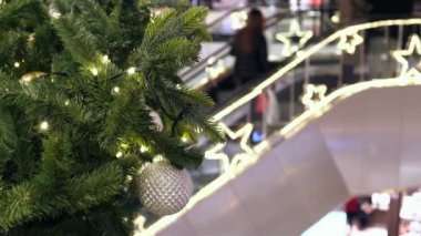 Sopping Mall 'da Noel süsleri. Şenlik alışveriş merkezinde yürüyen merdivendeki insanlar yeni yıl alışverişi yaparlar.,.