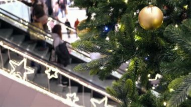 Sopping Mall 'da Noel süsleri. Şenlik alışveriş merkezinde yürüyen merdivendeki insanlar yeni yıl alışverişi yaparlar.,.