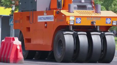 Şehir caddesinde çalışan yol silindirleri. Yeni otoyolun yapımında ağır endüstriyel makineler.