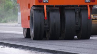Şehir caddesinde çalışan yol silindirleri. Yeni otoyolun yapımında ağır endüstriyel makineler.