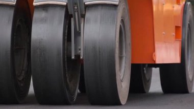 Şehir caddesinde çalışan yol silindirleri. Yeni otoyolun yapımında ağır endüstriyel makineler.