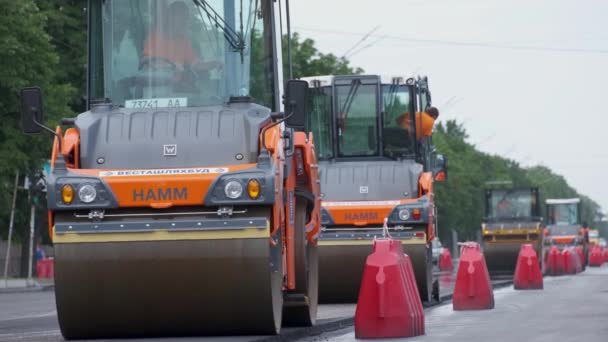 롤러들 도시의 거리에서 일하고 있습니다 새로운 도로를 건설하고 중공업 기계들 — 비디오