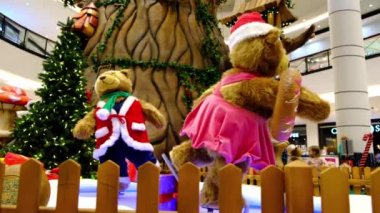Noel Baba süitleri giymiş iki büyük yapay ayı bebek kayak yapıyor. alışveriş merkezinde