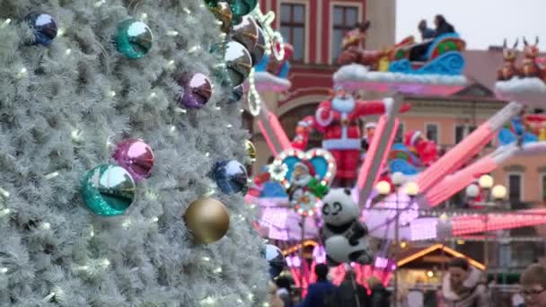 Mensen rijden op een draaimolen op een versierde kerstmarkt op een feestelijk plein in het centrum van de stad op winterdag. — Stockvideo